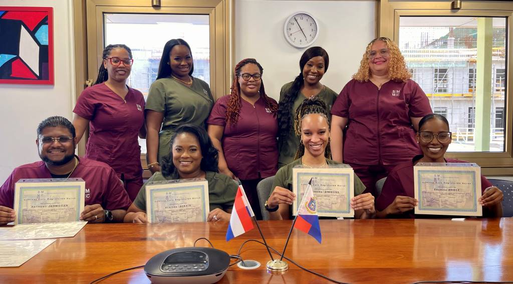 Group of nurses celebrating CCRN certification success with diplomas in a hospital break room.